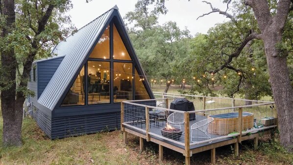 Enjoy your own private deck outside of these beautiful floor to ceiling windows, with propane fire pit, grill, and heated stock tank pool. !Photo credit @mikewilltravel
