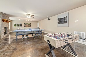An epic game room featuring a foosball table, dartboard, a ping pong table, and plenty of space for fun and friendly competition - perfect for game nights and making great memories!