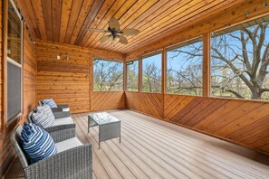 A peaceful screened-in porch, perfect for unwinding with a morning coffee, enjoying the fresh air without the bugs, or simply soaking in the serene surroundings.