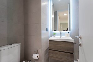 Experience modern comfort in this stylish bathroom, featuring sleek finishes and thoughtful details for a refreshing stay.