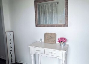 The foyer welcomes you to the home. There is a boot tray to collect your work boots and shoes near the front door. You can go right to the laundry room, bathroom 2, and BR4; you can go left to the shared living areas, and BRs 1-3.