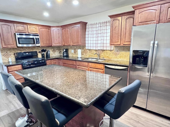 The well stocked shared kitchen has all the cookware, dishes, and utensils for cooking or prepping meals. There is seating for 4 at the large granite center island.