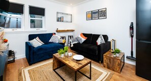 Relax in style! Our cozy living room features two comfy sofas and a 50” TV—perfect for movie nights or unwinding after a long day.