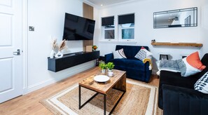Relax in style! Our cozy living room features two comfy sofas and a 50” TV—perfect for movie nights or unwinding after a long day.
