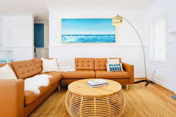 Leather sofa in an open floor-plan where surf style meets Scandinavian modern
