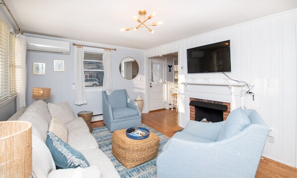 Bright and welcoming living area with a cozy fireplace, perfect for relaxing after exploring nearby Falmouth.