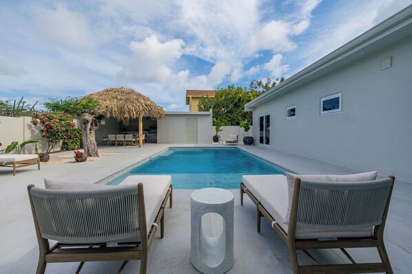 This home features a perfect spot to unwind with a cozy lounge chair, ideal for reading, enjoying a cup of coffee, or simply soaking in the ambiance. Whether you’re lounging indoors or by the pool, comfort is always within reach.