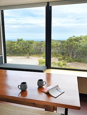 Generous windows bring the ocean and bushland views into the home.