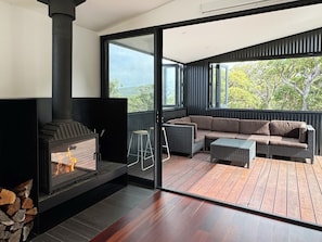 A cozy fireplace for those cold winter nights. The living area opening out onto a beautiful undercover deck.