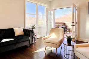 Enjoy an afternoon in our spacious living room with French doors to the balcony that overlooks the French Broad River and Silver Line Park.