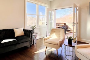 Enjoy an afternoon in our spacious living room with French doors to the balcony that overlooks the French Broad River and Silver Line Park.