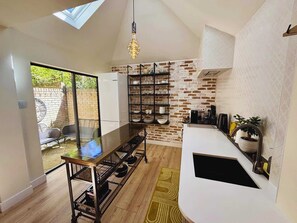 Loving the rustic-industrial vibe—exposed brick, open shelves, and sleek black accents. The glass door brings in great natural light, keeping it bright and modern.