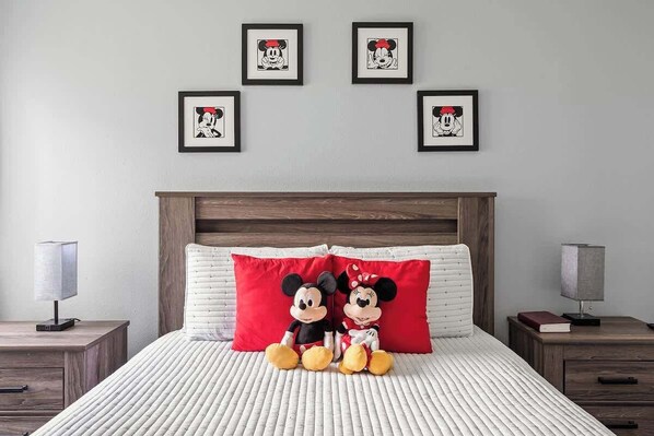 Mickey and Minnie -themed bedroom with a queen bed and a TV.