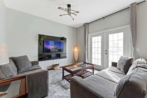 Luminous living room with tv and a wonderful view of the outdoors.