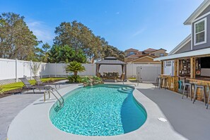Relax in the crystal-clear pool surrounded by lush landscaping.