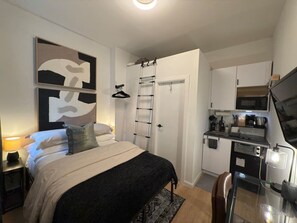 Okay, so NYC isn't exactly known for its silence, but this space is surprisingly peaceful thanks to the cozy glow of the ceiling light. Plus, there's a handy clothes hanger, so unpacking is quick and easy