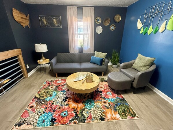 The cozy living room features a convertible couch, smart TV, and inviting décor.