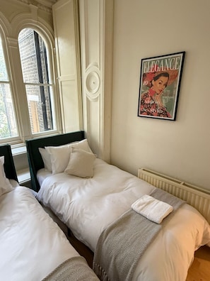 Tha main en suite twin bedroom with arched windows