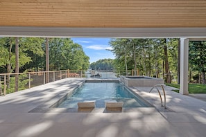 Large pool with loungers and attached hot tub.