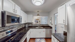 Plenty of cabinet and counter space combined with high end stainless-steel appliances make this well-equipped kitchen a chef's dream.