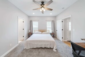 Bedroom 1: A spacious master bedroom with a large bed, a work desk, and ample natural light, offering a serene and relaxing atmosphere.