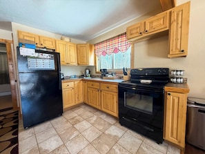 Full Kitchen featuring a refrigerator and freezer, electric range and microwave.