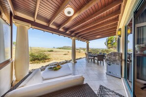 Spacious terrace with BBQ, dining set, lounge area, and relaxing golf course view.