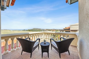 Master bedroom balcony with ocean & gold course view and comfortable furniture