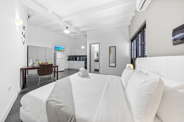 Air-conditioned bedroom with a comfortable queen bed and workspace.