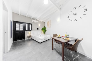 Bright living space with a cozy dining area and a comfortable bed.