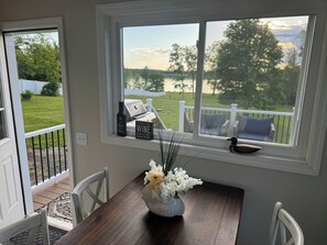 Breakfast nook overlooking back deck, yard, and lake