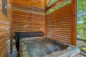 Enjoy privacy and comfort as you relax in the hot tub, surrounded by natural wood and peaceful views.