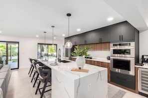 Kitchen is fully equipped with modern appliances, cookware, and a spacious dining area for a seamless cooking experience.