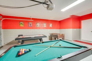 Fun-filled game room featuring a pool table, foosball, and air hockey for hours of entertainment.