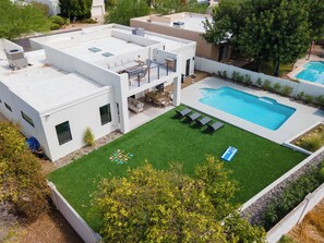 Spacious backyard with pool, games, loungers, and a rooftop lounge deck