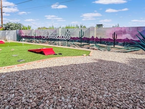 Play some cornhole with our new putting green showcasing the new wall mural.