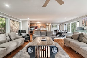 Large windows fill the living room with light, creating a warm ambiance.