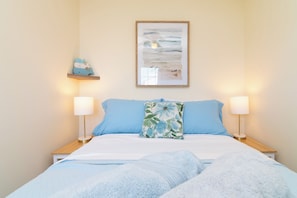 1st fl bedroom includes a full size bed, a closet, smart tv, lighting and desk.
