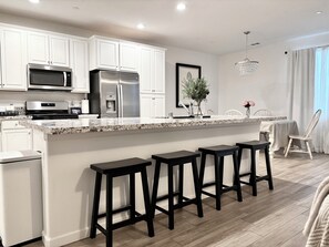 Kitchen with large island with 4 stools; upgraded cabinets, granite counters