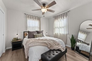 Bedroom 1 (with black bench and mirror) 🛏️ Relax in a plush queen bed surrounded by soft natural light.
