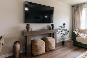 TV Console Close-Up 📺 Stylish console and decor beneath a large smart TV for your entertainment needs.