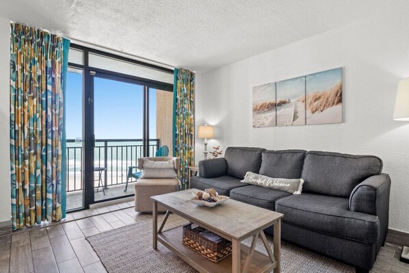 Experience oceanfront comfort and style in this cozy living room with a queen sleeper sofa. Step onto the balcony and soak up the sun and stunning views from the desirable Sunrise Tower in North Myrtle Beach.