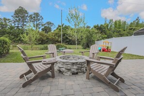 Spacious backyard with firepit, basketball hoop, and room to play.