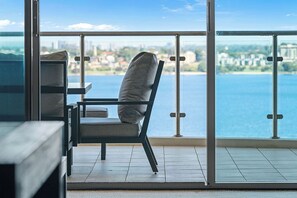 Enjoy the seamless blend of indoor and outdoor living with a glass railing that provides an unobstructed panorama. The balcony is thoughtfully furnished with a stylish dark-colored table, ideal for alfresco dining or simply enjoying the peaceful ambiance.