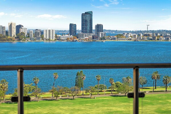 Indulge in unparalleled panoramic views from this stunning apartment, where the vibrant cityscape meets the tranquil beauty of the river. This image captures the essence of your stay: a private balcony offering a front-row seat to a captivating urban panorama.