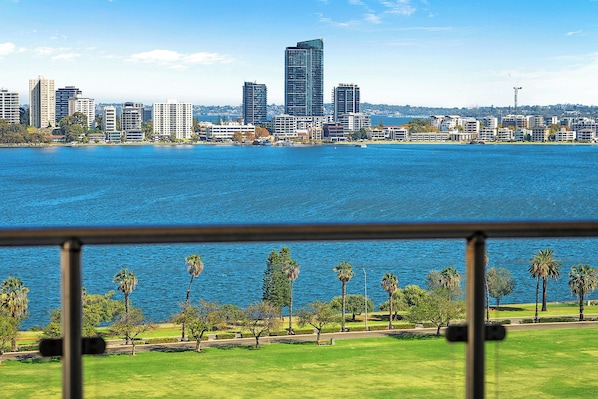 Indulge in unparalleled panoramic views from this stunning apartment, where the vibrant cityscape meets the tranquil beauty of the river. This image captures the essence of your stay: a private balcony offering a front-row seat to a captivating urban panorama.