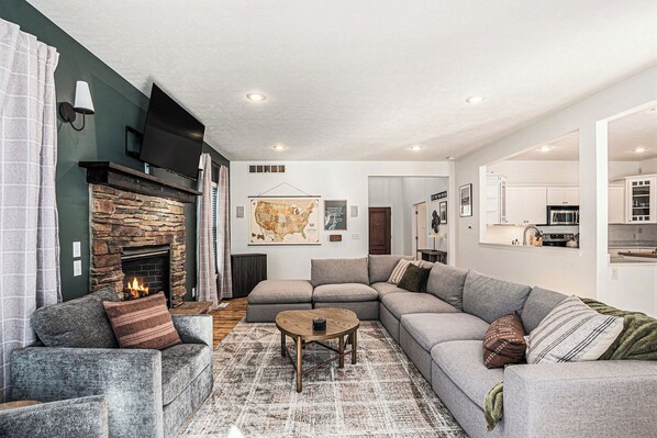 Cozy up around the fireplace—game nights, movie marathons, or morning coffee happen here.