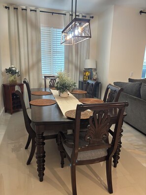 Dining room includes large wooden table with 6 chairs