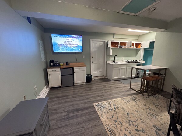 Kitchenette with a four-burner electric stove and mini fridge with freezer