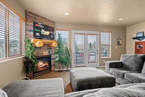 Enjoy movie nights on the large smart TV, or take in the natural beauty through the expansive windows flanking the patio doors, which lead out to the deck.